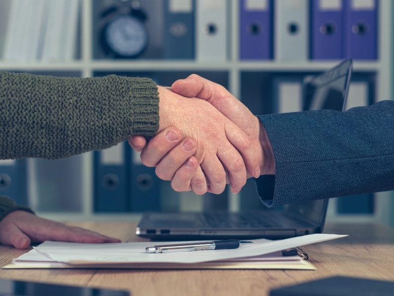 Man and woman shake hands over business agreement. Start up business female entrepreneur making handshake deal with large corporate company for selling small business.